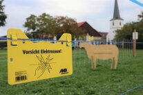 Gelbes Schild warnt vor Elektrozaun