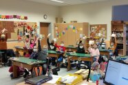 Kinder in Klassenzimmer halten Zettel in die Höhe
