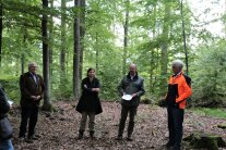 Vier Personen stehen in einem Wald